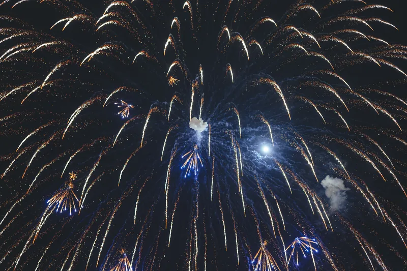 An immense canopy of golden fireworks and blue sparks overhead